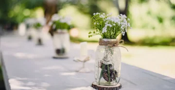 Mason jar filled with water and fresh herb stems as a kitchen table centerpiece
